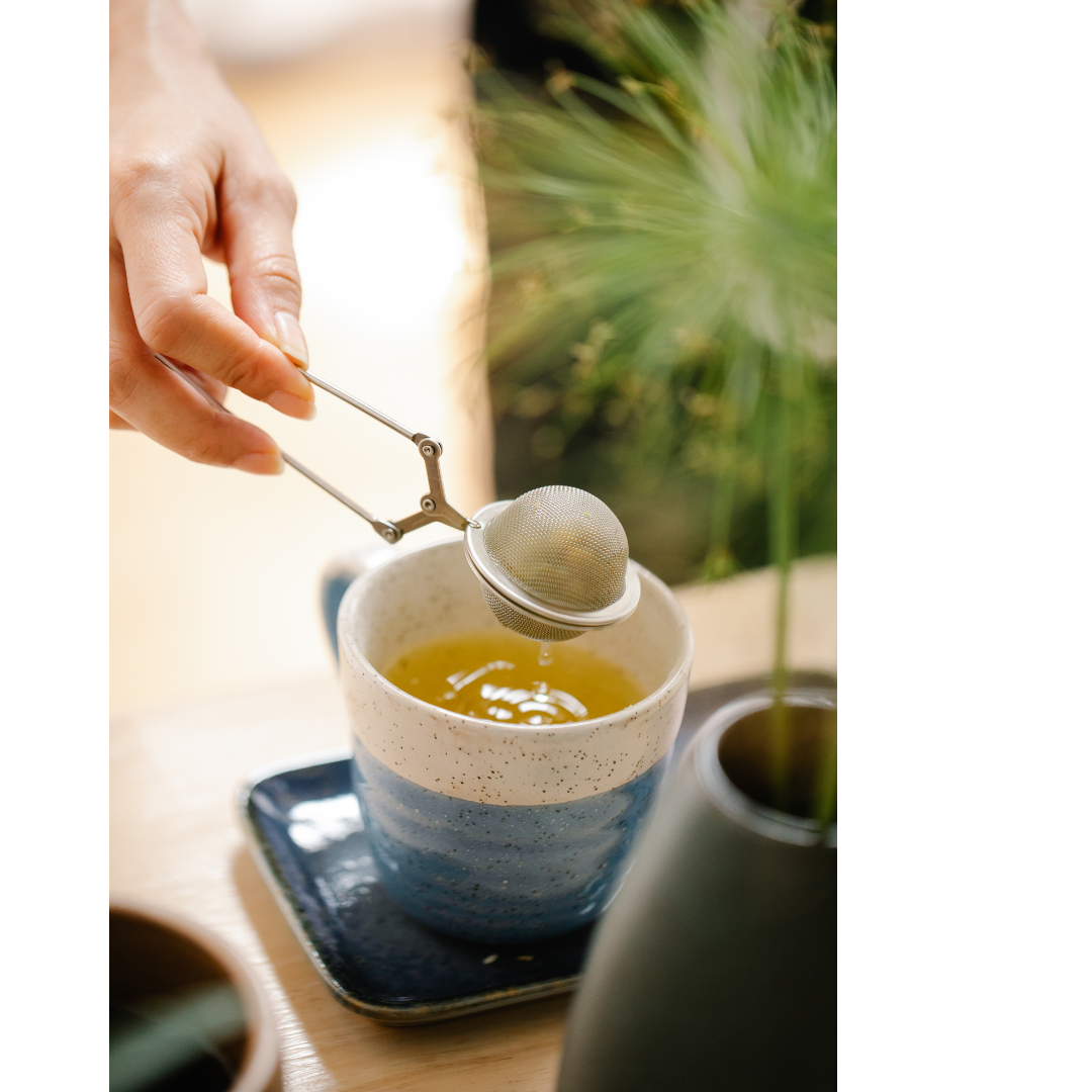 A morning ritual: loose-leaf tea steeping over a ceramic cup